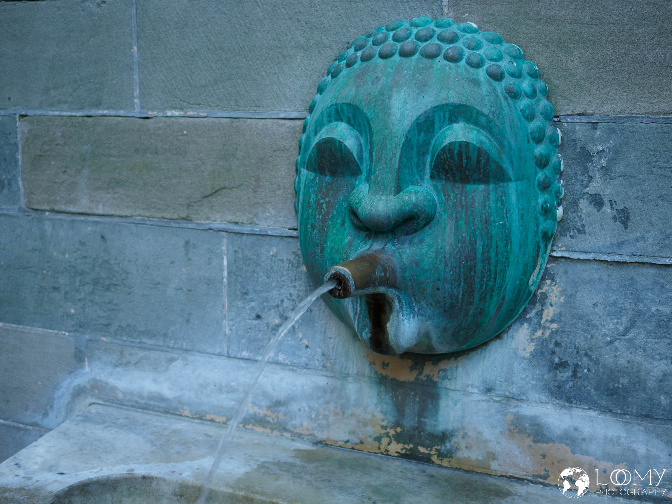 Wandbrunnen mit wasserspeiender Bronzemaske